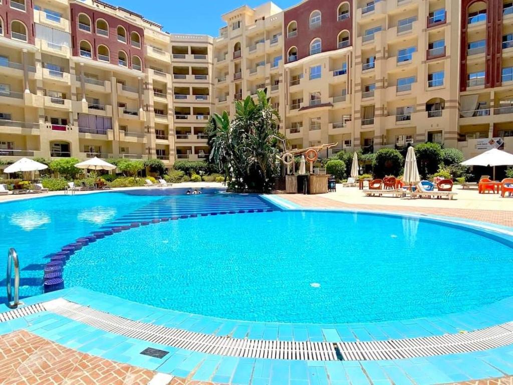 Luxury swimming pool at Florenza Khamsin surrounded by palm trees and elegant resort-style architecture.